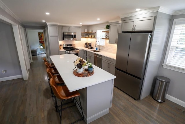 796 Foundry St, Easton, MA 02375 - kitchen with appliances with stainless steel finishes, gray cabinetry, open shelves, a kitchen bar, and tasteful backsplash