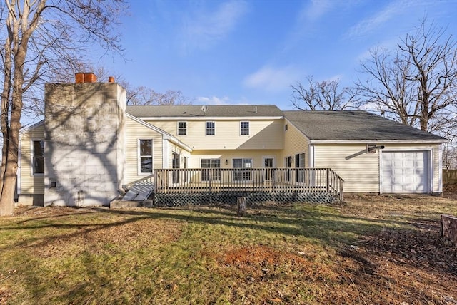 back of property featuring a lawn, a garage, and a wooden deck