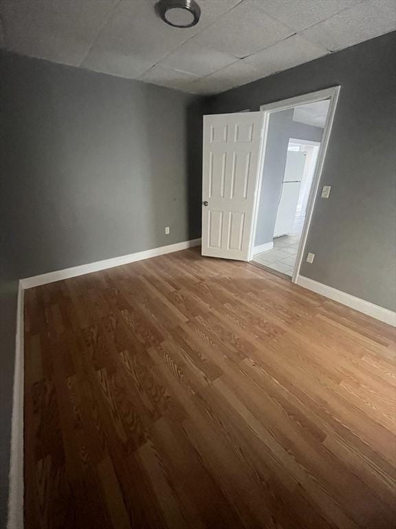 422 County St, Fall River, MA 02723 - unfurnished bedroom with wood finished floors, a drop ceiling, and baseboards