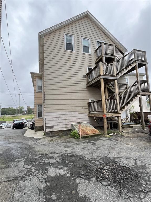 422 County St, Fall River, MA 02723 - back of property featuring a wooden deck, stairs, and a balcony