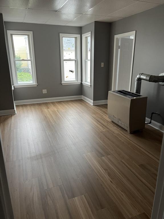 422 County St, Fall River, MA 02723 - unfurnished living room featuring wood finished floors, baseboards, plenty of natural light, and a paneled ceiling