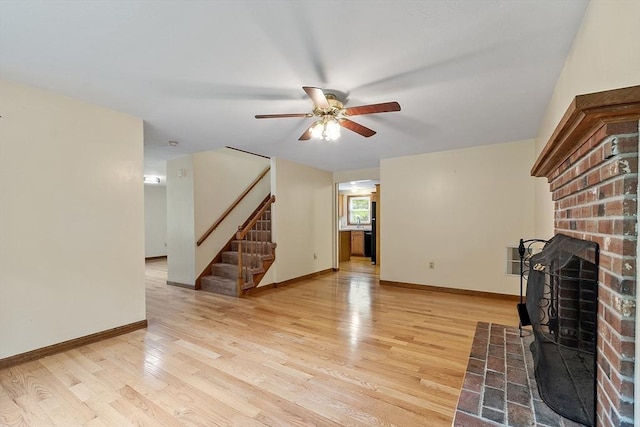 71 Johnny Appleseed Ln, Leominster, MA 01453 - unfurnished living room featuring stairway, a ceiling fan, light wood-style floors, baseboards, and a fireplace