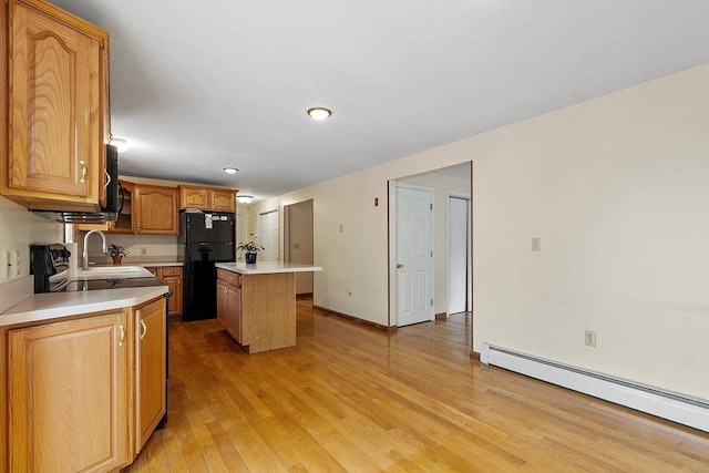71 Johnny Appleseed Ln, Leominster, MA 01453 - kitchen with freestanding refrigerator, baseboard heating, a kitchen island, light countertops, and light wood finished floors