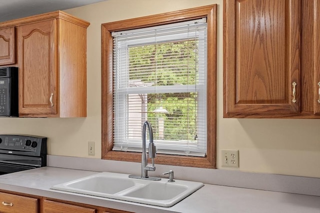 71 Johnny Appleseed Ln, Leominster, MA 01453 - kitchen with a sink, black appliances, healthy amount of natural light, and light countertops
