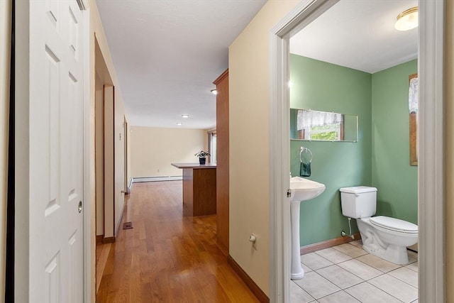 71 Johnny Appleseed Ln, Leominster, MA 01453 - corridor featuring a baseboard radiator, baseboards, and light wood-style floors
