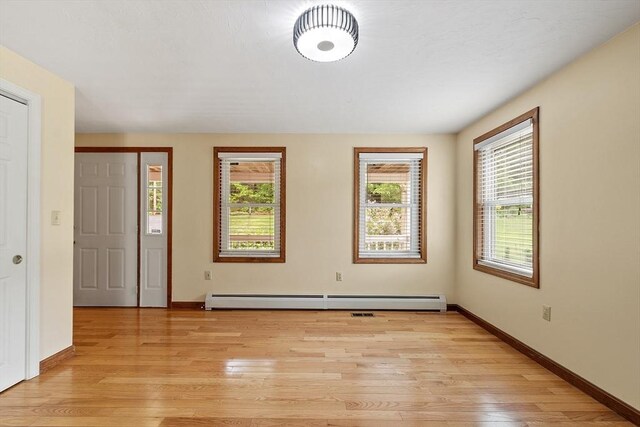 71 Johnny Appleseed Ln, Leominster, MA 01453 - unfurnished bedroom with baseboard heating, light wood-style flooring, multiple windows, and baseboards