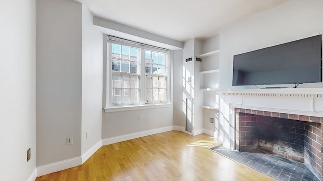 unfurnished living room with light hardwood / wood-style floors and built in features