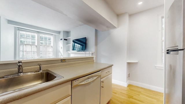 kitchen featuring light hardwood / wood-style floors, stainless steel refrigerator, sink, and dishwasher