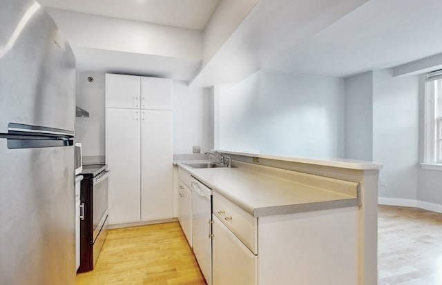 kitchen with stainless steel appliances, light hardwood / wood-style floors, white cabinets, kitchen peninsula, and sink