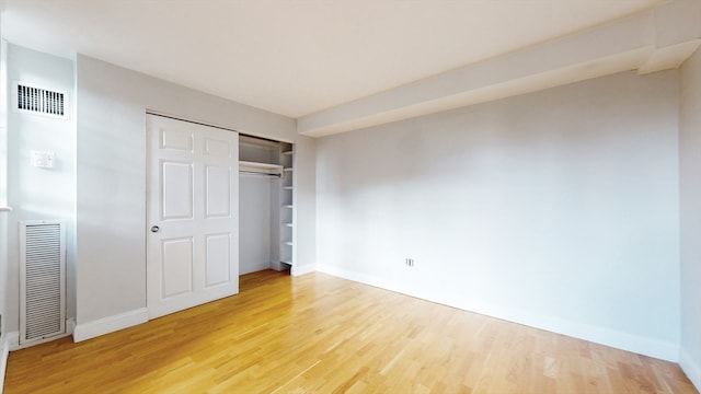 unfurnished bedroom featuring hardwood / wood-style flooring and a closet