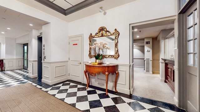 entrance foyer featuring ornamental molding and dark colored carpet