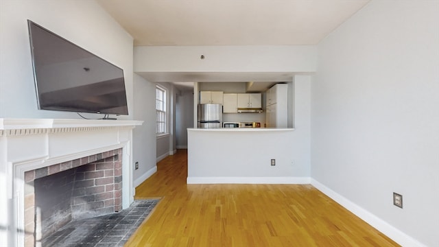 unfurnished living room featuring light hardwood / wood-style floors and a fireplace