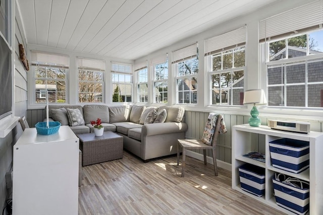 sunroom / solarium with healthy amount of natural light, wooden ceiling, wood finished floors, and a wooden deck