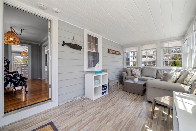 sunroom / solarium with wood finished floors and ornamental molding
