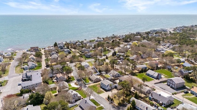 aerial view of property and surrounding area featuring nearby suburban area and a large body of water