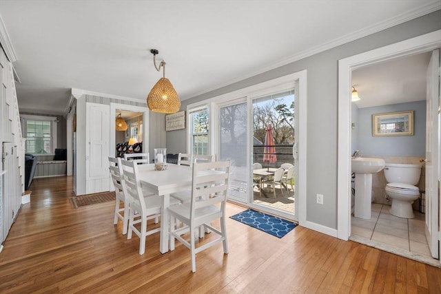 dining room featuring ornamental molding, hardwood / wood-style flooring, and baseboards