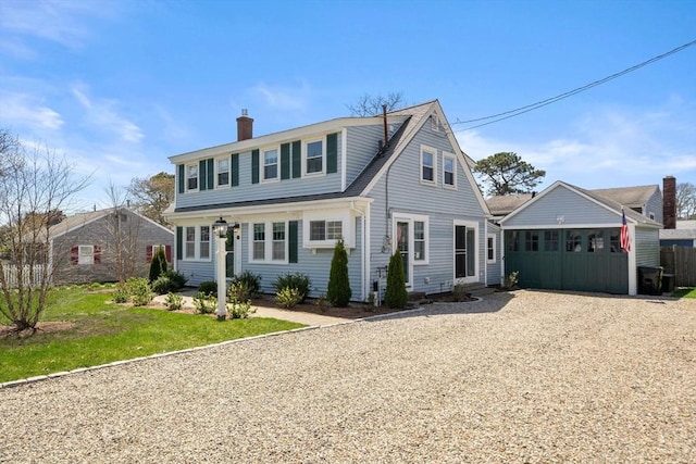 view of front of house featuring a chimney and driveway