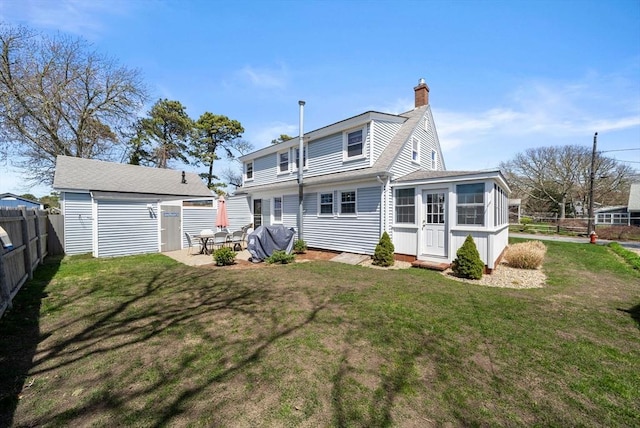 rear view of property featuring an outbuilding and a chimney
