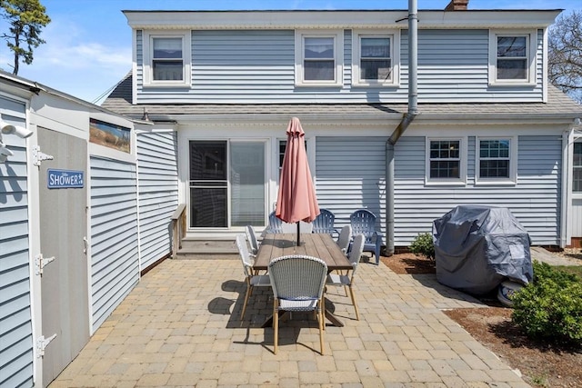 rear view of property featuring a patio and outdoor dining area