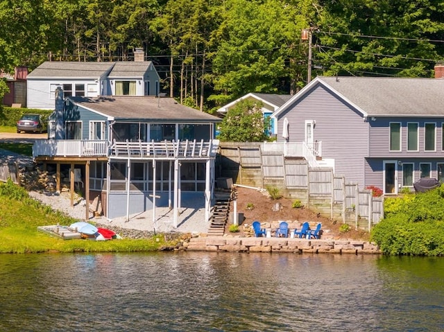 11 Hamilton Dr, Holland, MA 01521 - rear view of house with stairs, a sunroom, a chimney, a deck with water view, and a patio