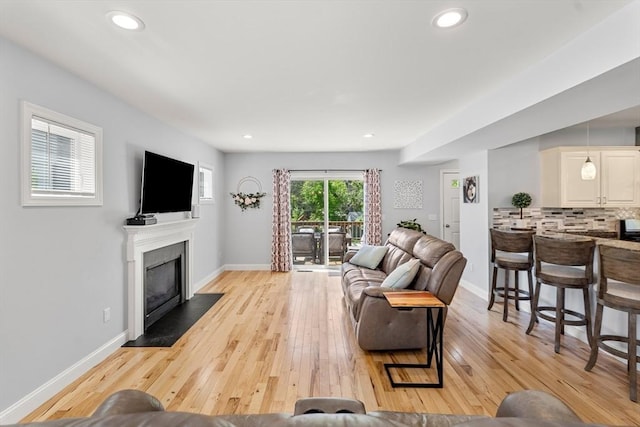 10 Brickett Ave, Haverhill, MA 01830 - living area featuring a fireplace with flush hearth, light wood-type flooring, baseboards, and recessed lighting