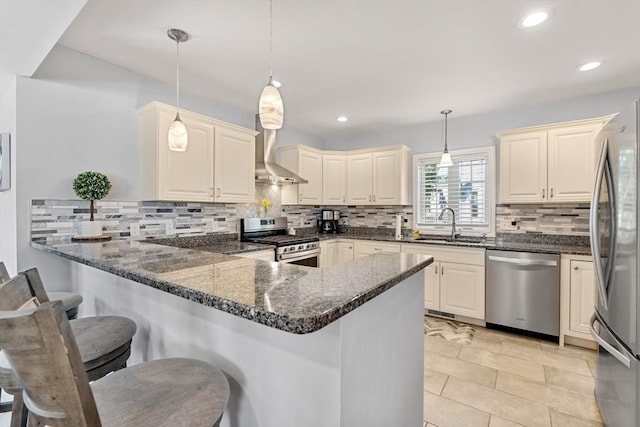 10 Brickett Ave, Haverhill, MA 01830 - kitchen with stainless steel appliances, wall chimney range hood, a peninsula, a sink, and decorative backsplash