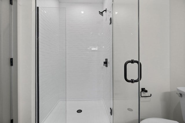 bathroom with an enclosed shower and toilet