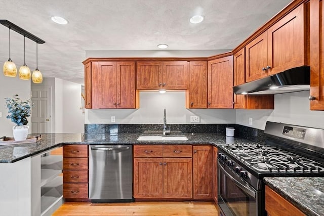 kitchen with a sink, brown cabinets, under cabinet range hood, and stainless steel appliances