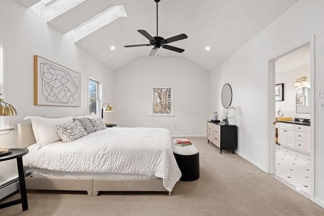 bedroom with a ceiling fan, baseboards, lofted ceiling, ensuite bathroom, and light colored carpet