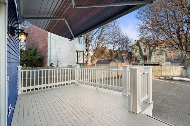 deck with a storage shed, an outbuilding, and fence