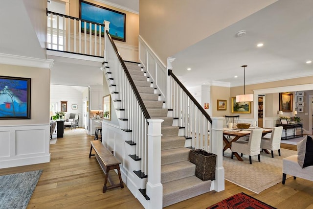 27 Gully Ln, Sandwich, MA 02537 - stairs with ornamental molding, a decorative wall, wood finished floors, recessed lighting, and a wainscoted wall