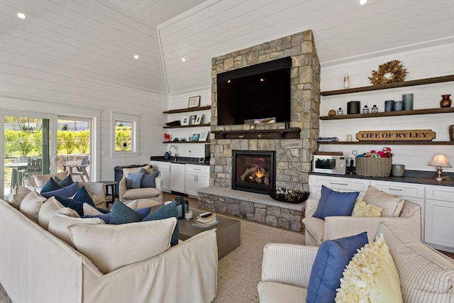 27 Gully Ln, Sandwich, MA 02537 - living area with a stone fireplace, lofted ceiling, wooden walls, and recessed lighting