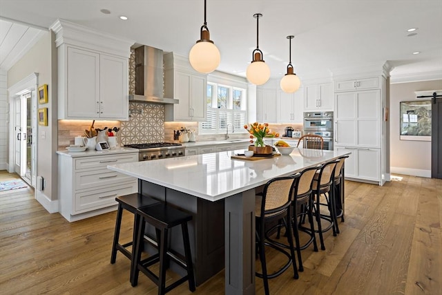 27 Gully Ln, Sandwich, MA 02537 - kitchen with wall chimney range hood, ornamental molding, stainless steel appliances, white cabinets, and recessed lighting
