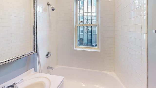 bathroom with tiled shower / bath combo and vanity