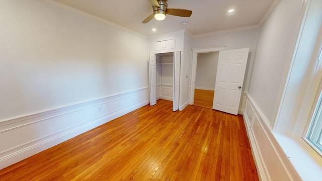 unfurnished bedroom featuring ceiling fan, a closet, light hardwood / wood-style floors, and ornamental molding