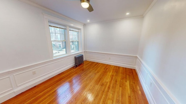 unfurnished room with radiator, crown molding, light hardwood / wood-style flooring, and ceiling fan