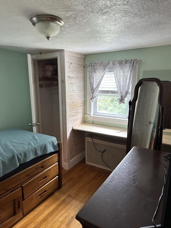10 Marilyn Dr, Auburn, MA 01501 - bedroom featuring radiator, light wood finished floors, a textured ceiling, and a closet