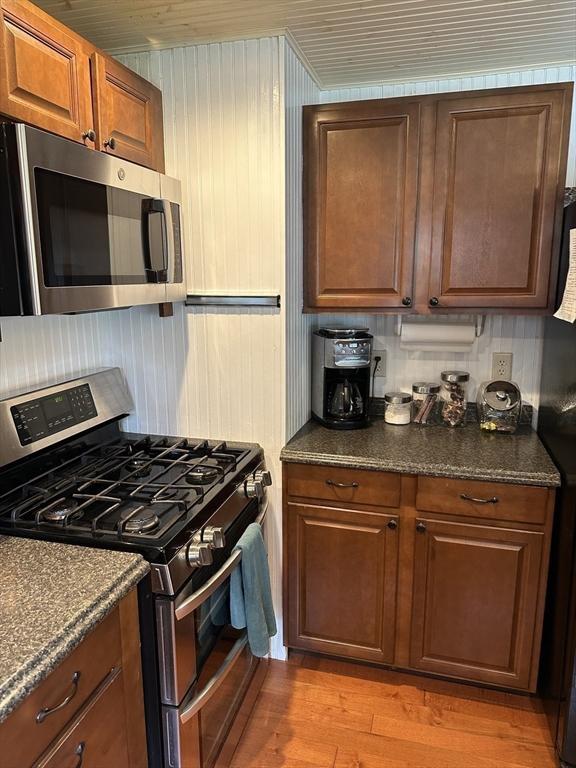 10 Marilyn Dr, Auburn, MA 01501 - kitchen featuring stainless steel appliances, wood finished floors, brown cabinets, and dark stone counters