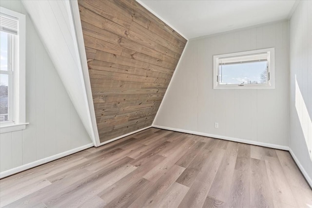 additional living space with lofted ceiling and light hardwood / wood-style flooring