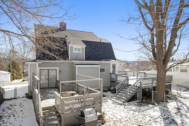 snow covered house featuring a deck