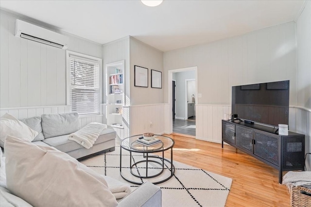 living room with hardwood / wood-style flooring and a wall mounted air conditioner