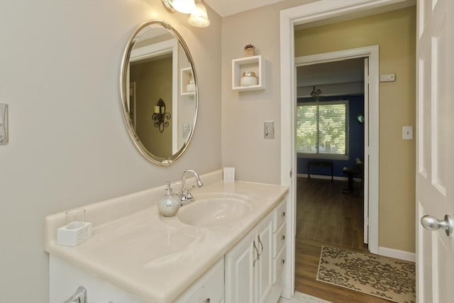 bathroom featuring wood finished floors, vanity, and baseboards