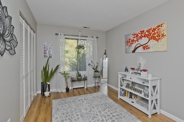 sitting room featuring visible vents, baseboards, and wood finished floors