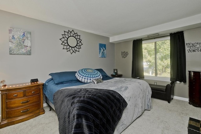 bedroom featuring light carpet and baseboards