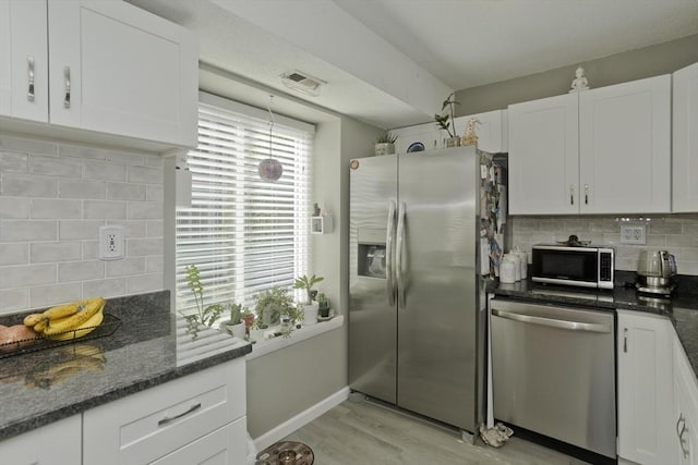 kitchen featuring stainless steel appliances, white cabinets, visible vents, and light wood-style flooring