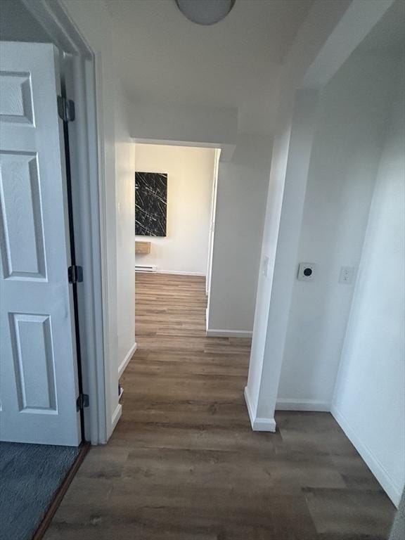 hall with dark wood-type flooring and baseboards