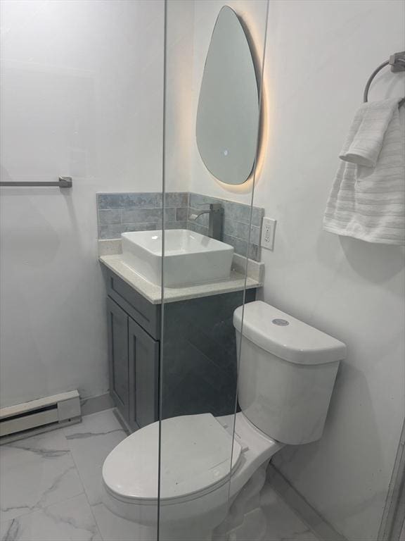 bathroom with toilet, marble finish floor, a baseboard radiator, and vanity