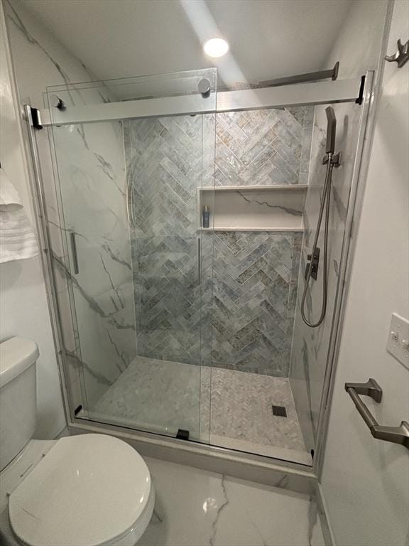 full bath featuring toilet, marble finish floor, and a marble finish shower