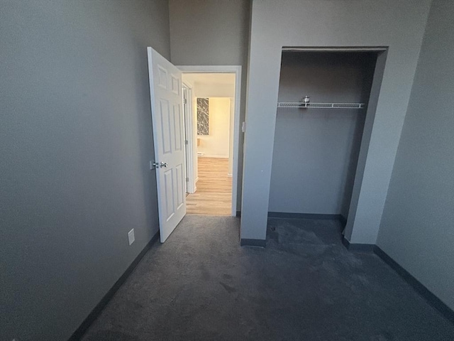 unfurnished bedroom with a closet, carpet flooring, and baseboards