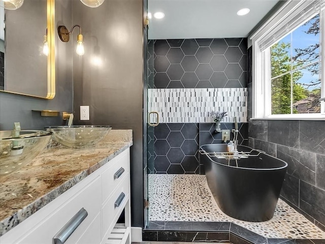 full bathroom with a freestanding tub, a shower stall, and vanity